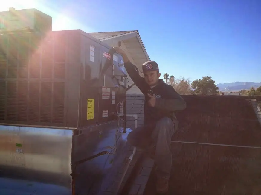 HVAC technician performing Heat Pump Repair on a rooftop unit in Whittier